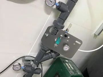 Injection panel with flow meter and pressure gauge downstream of a batch pump, above an oxygen concentrator