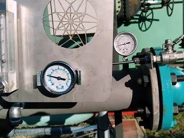 Stainless metering panel with a rotameter and pressure gauges beside the injector flange