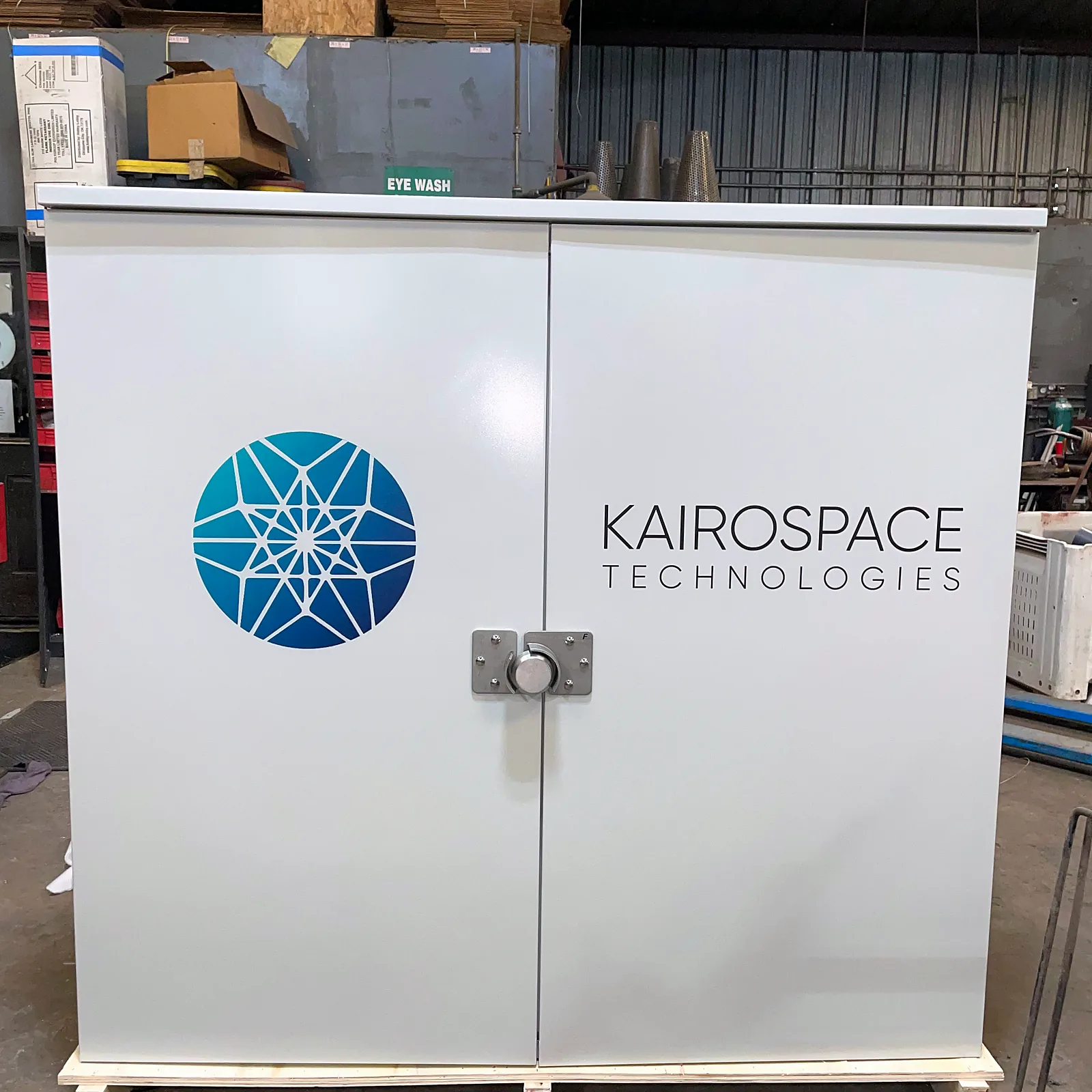 Kairospace oxygen concentrator cabinet strapped to a wooden pallet in the shop before shipping